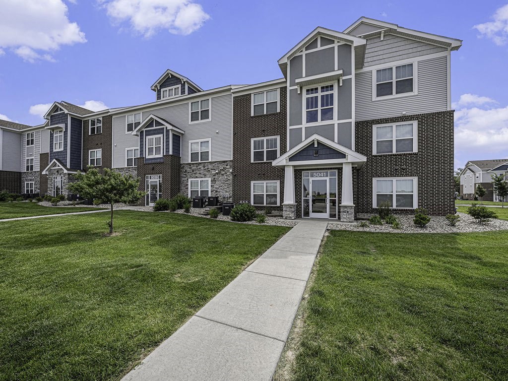 well maintained apartment building with grass at Trade Winds Apartment Homes in Elkhorn, NE 68022