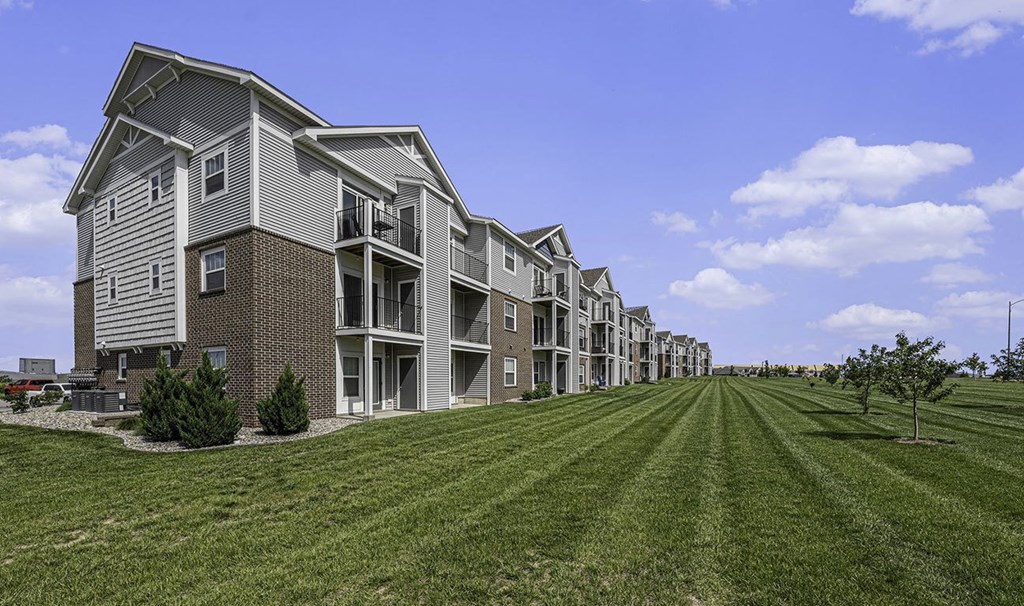 exterior of an apartment buildings with private patios and balconies at Trade Winds Apartment Homes in Elkhorn, NE 68022