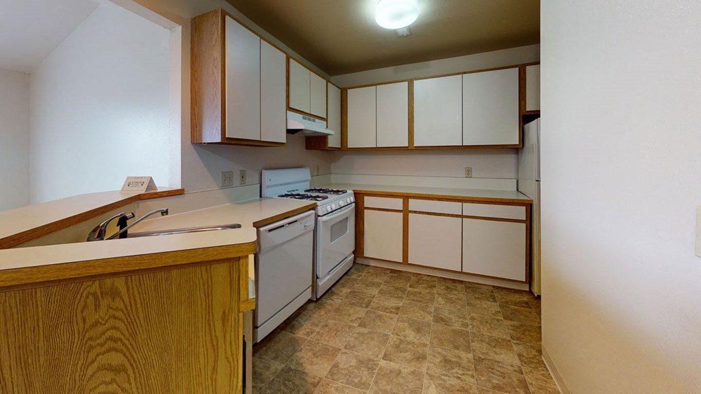 a kitchen with white appliances  at Trappers Cove Apartments, Lansing, MI, 48910