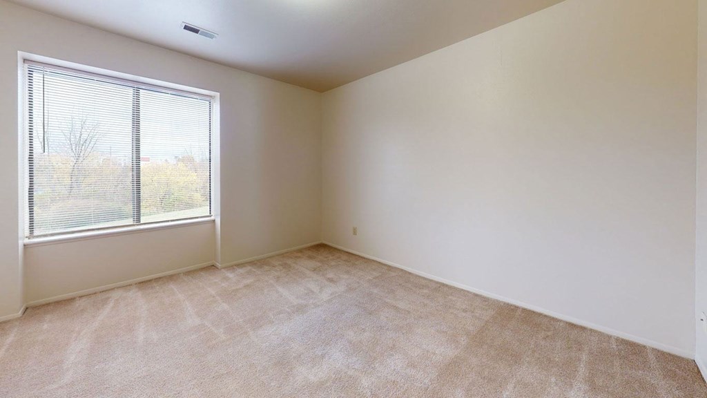 bedroom with a large window  at Trappers Cove Apartments, Lansing, 48910