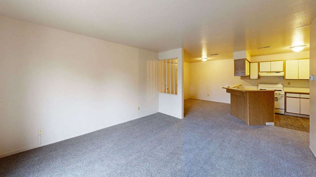living and dining room with plush carpeting  at Trappers Cove Apartments, Lansing, MI