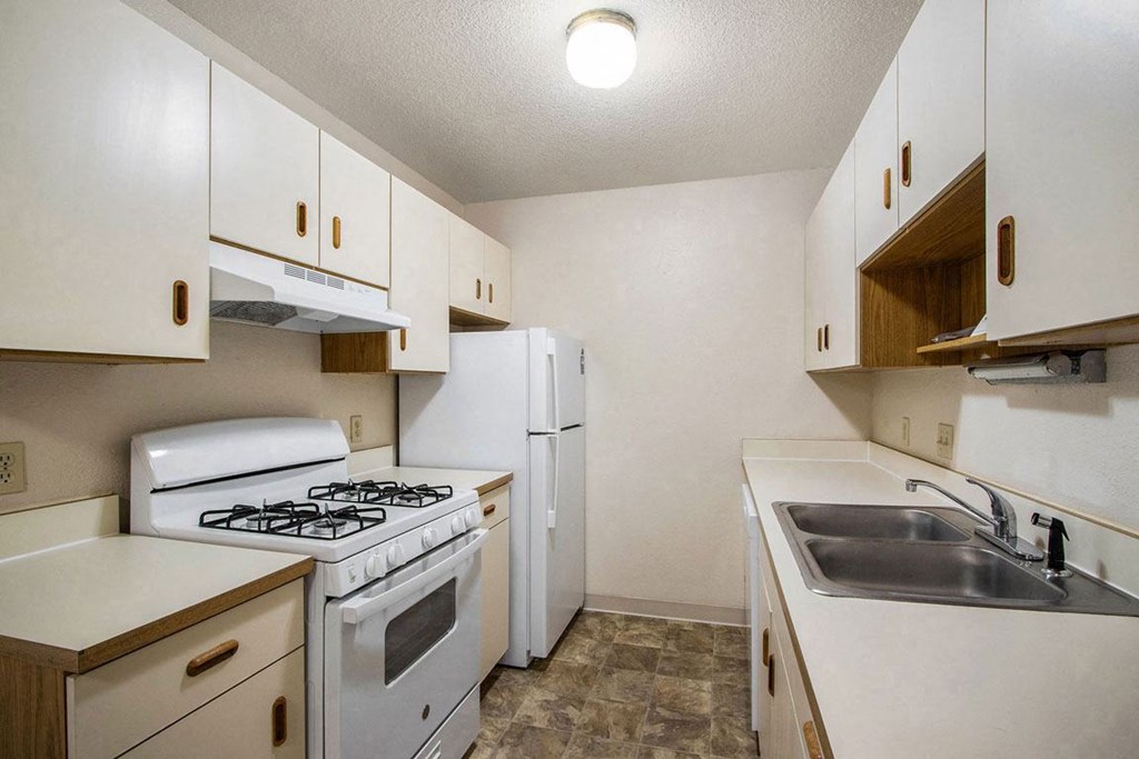a kitchen with white appliances at Trappers Cove Apartments, Lansing, 48910