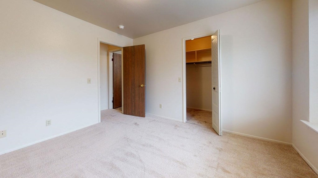 bedroom with a door to a closet  at Trappers Cove Apartments, Michigan
