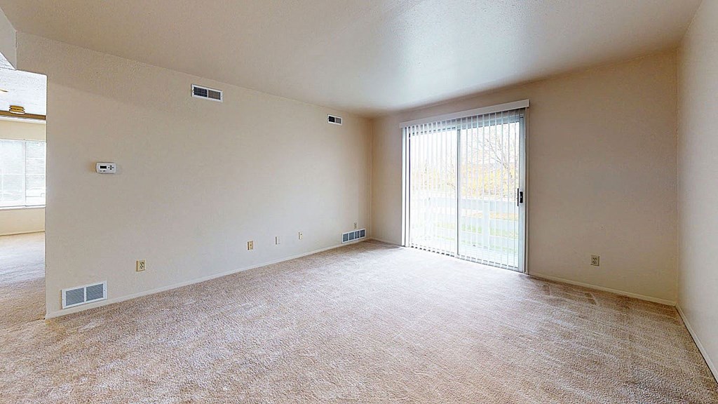 living room with a sliding glass door to private patio  at Trappers Cove Apartments, Lansing, 48910