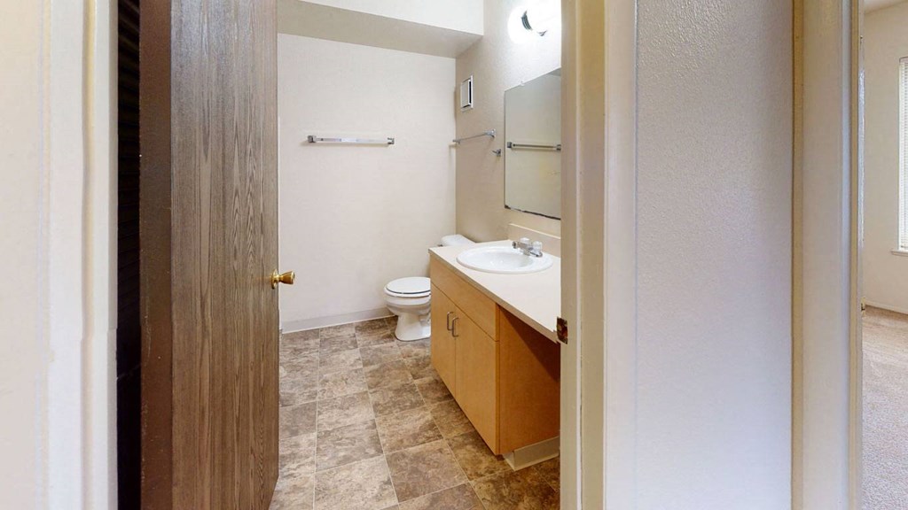 a bathroom with a toilet and a sink  at Trappers Cove Apartments, Lansing, Michigan