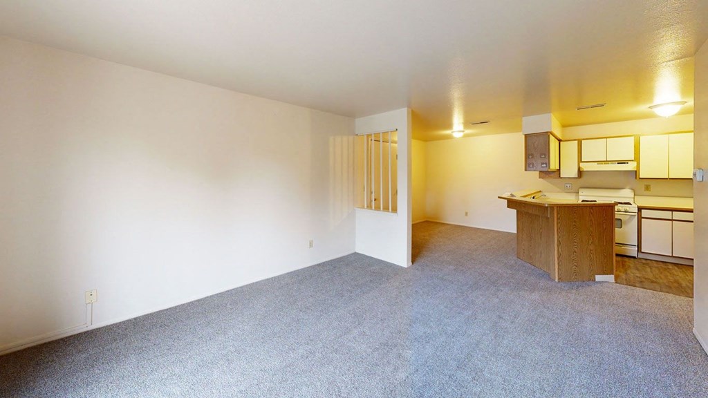 the living room and dining room with breakfast bar  at Trappers Cove Apartments, Lansing, MI