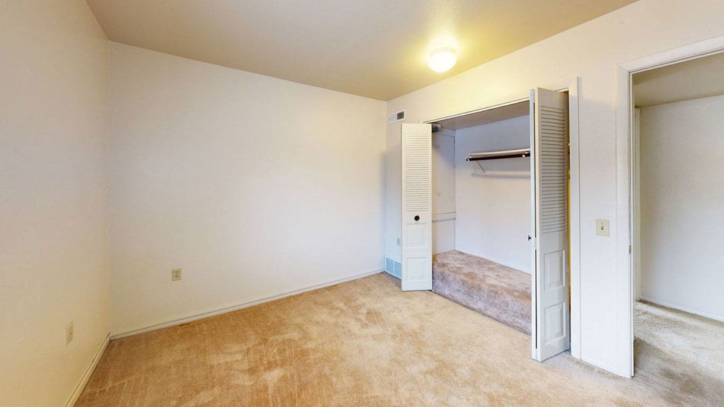a bedroom with a large closet at Trappers Cove Apartments, Lansing, 48910