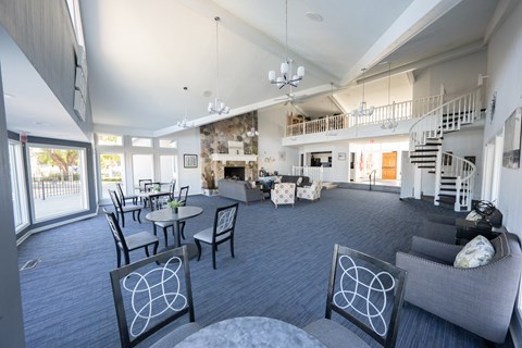 A living room with a grey couch and a fireplace.