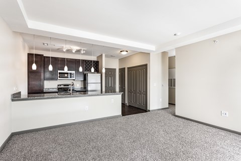 A kitchen with a refrigerator, microwave, and oven.