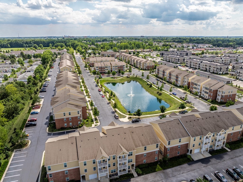 an aerial view of an apartment community with a pond in the middle at The Avenue at Polaris Apartments, Ohio