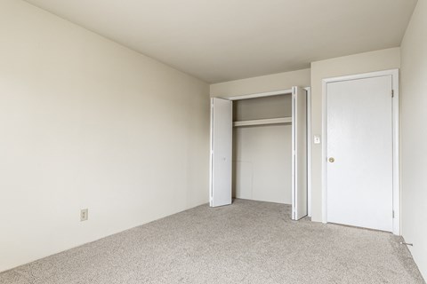 a bedroom with a closet and an open door at The Timbers Apartments, Evansville, IN, 47715