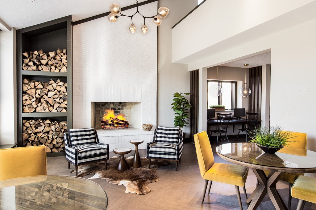 a living room with a fireplace and a table and chairs at The Timbers Apartments, Evansville, 47715