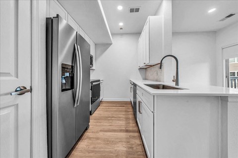 a kitchen with white cabinets and a stainless steel refrigerator