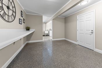 A hallway with a clock on the wall and a door on the right