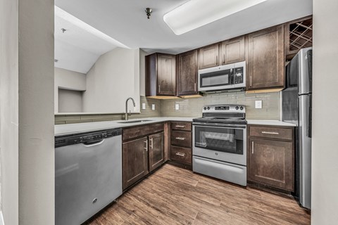 a kitchen with stainless steel appliances and wooden cabinets at Trophy Club at Bellgrade, Midlothian, VA, 23113