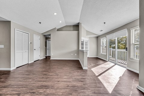 an empty living room with windows and a balcony at Trophy Club at Bellgrade, Midlothian, VA, 23113