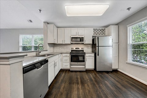 a kitchen with white cabinets and stainless steel appliances at Trophy Club at Bellgrade, Midlothian, VA, 23113