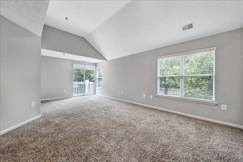 an empty living room with a large window and carpet at Trophy Club at Bellgrade, Midlothian, VA, 23113