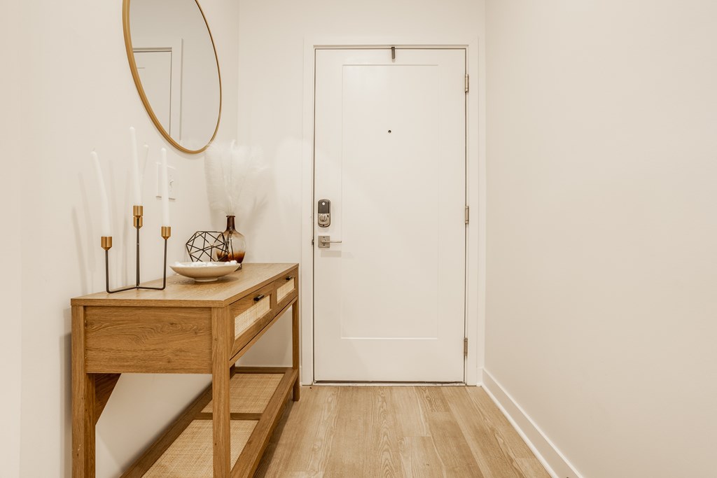 A white door is in a hallway with a wooden table and a mirror at Upper Vue Flats, Dublin