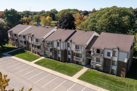 Apartment complex with a parking lot in front.