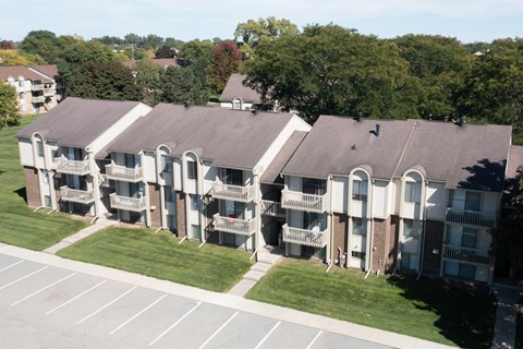 Apartment complex with a parking lot in front.
