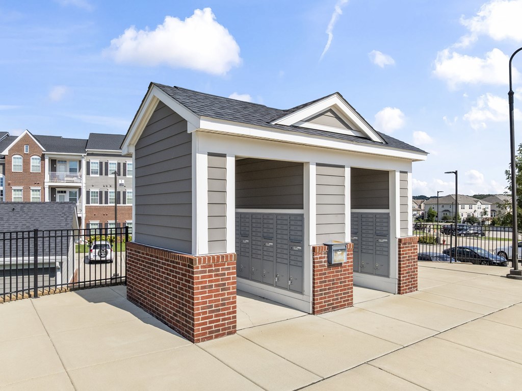 A small building with a grey roof and brick pillars.