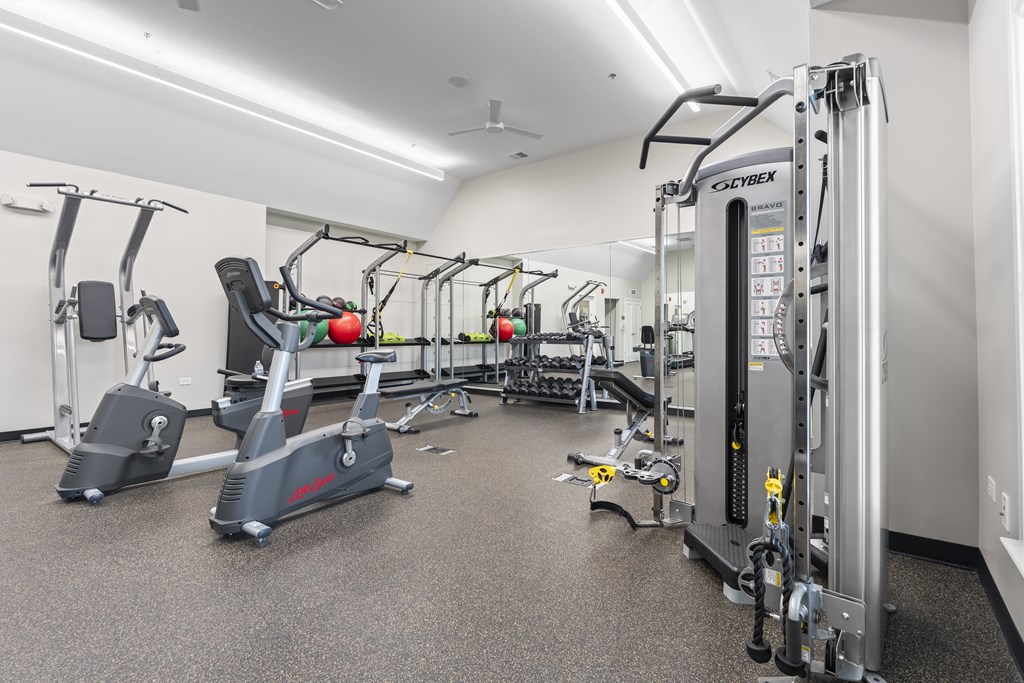 A gym with a variety of equipment including treadmills, stationary bikes, and weight machines.