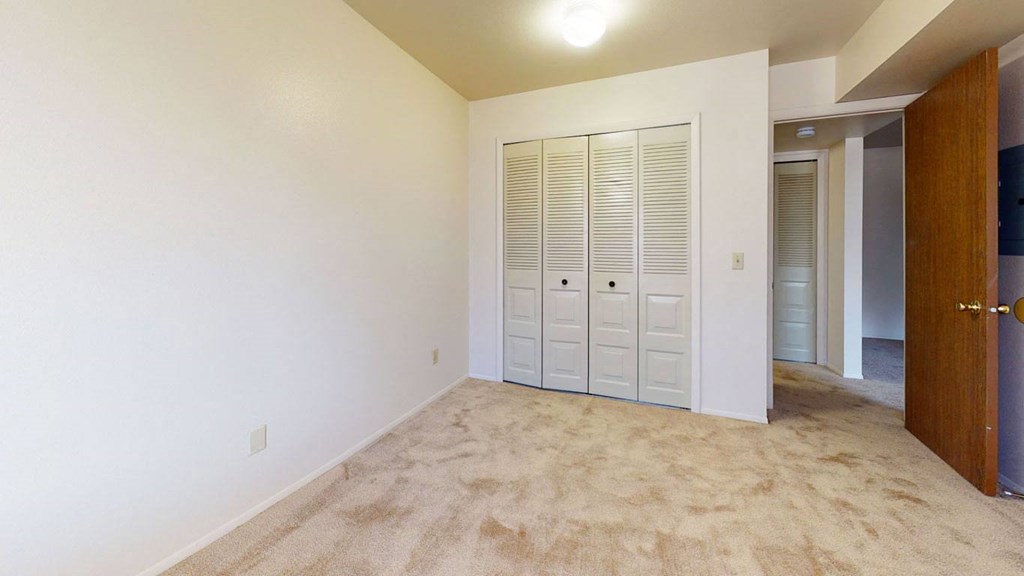 bedroom with a closet and plush carpeting at Walnut Trail Apartments in Portage, MI 49002