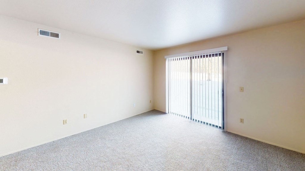 spacious living room with a sliding glass door to a private patio at Walnut Trail Apartments in Portage, MI 49002