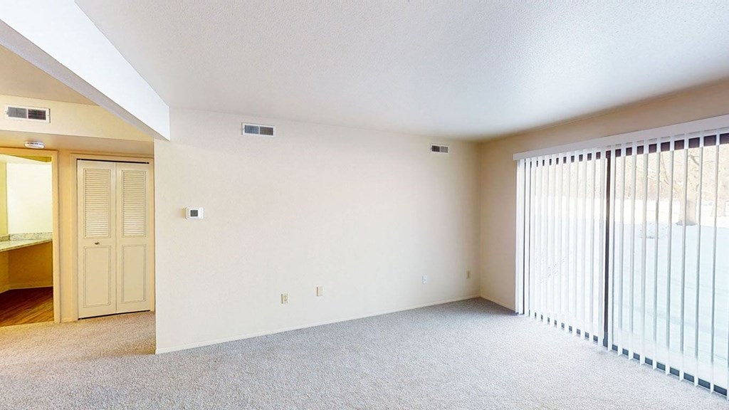a living room with a sliding door to a patio at Walnut Trail Apartments in Portage, MI 49002