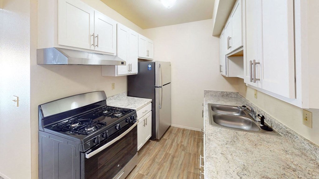 a renovated kitchen with stainless steel appliances and white cabinets at Walnut Trail Apartments in Portage, MI 49002