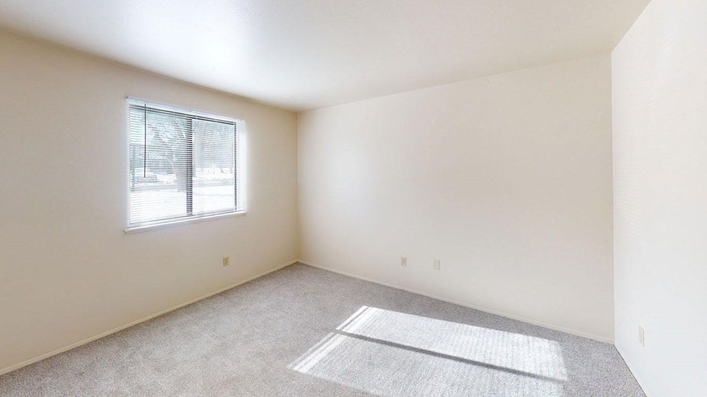 bedroom with a window and plush carpeting at Walnut Trail Apartments in Portage, MI 49002