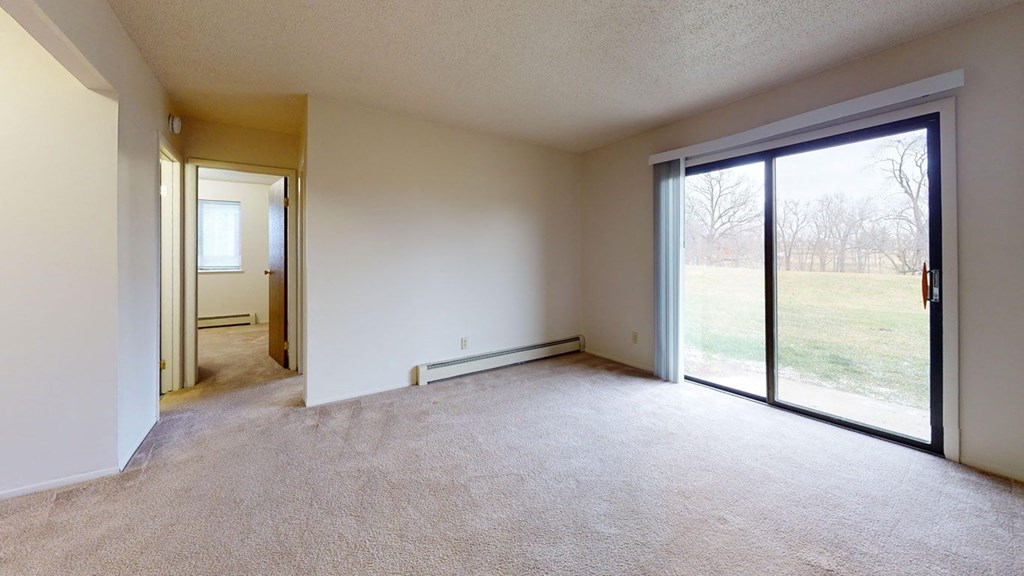 living room with sliding glass doors to a private patio at Waverly Park Apartments in Lansing, MI 48911