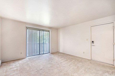 an empty living room with a door to a garage