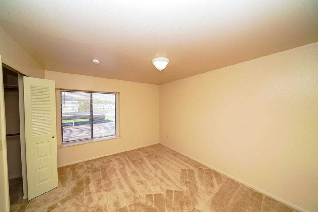bedroom with a large window and a walk-in closet