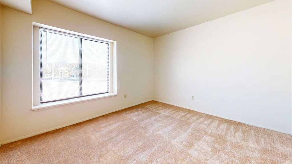 bedroom with a large window and carpeting