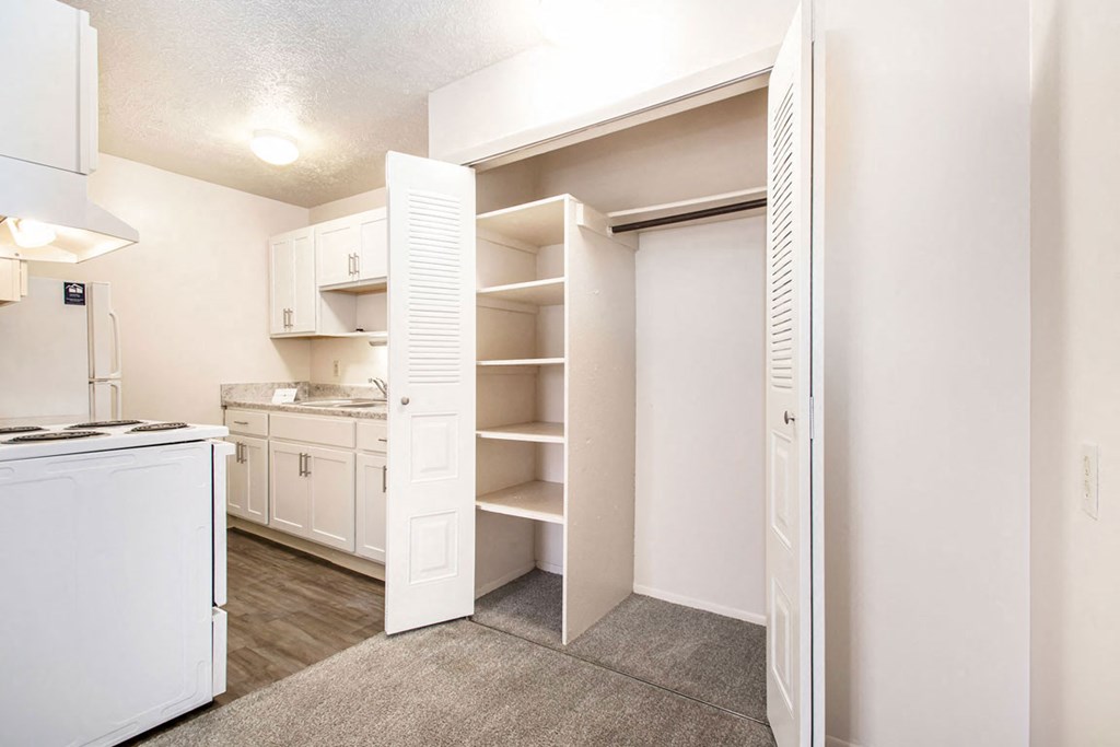 a renovated kitchen with white cabinets and a closet at Wingate Apartments, Kentwood, Michigan