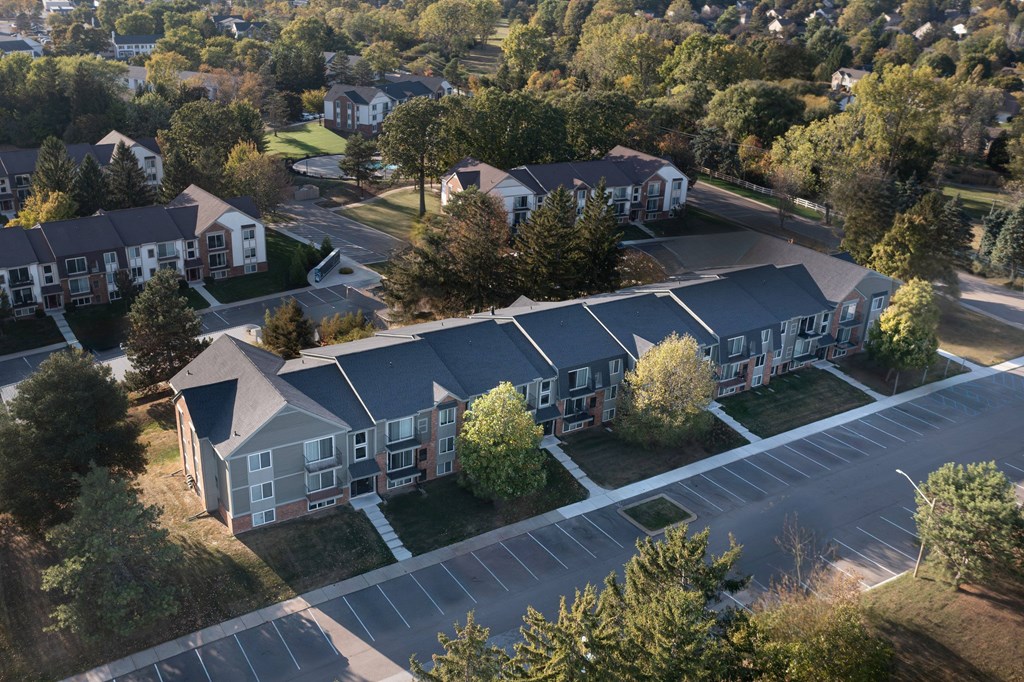 A large apartment complex with a parking lot in front.