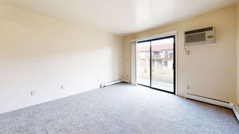 living room with a door to a patio  at Wood Creek Apartments, Kenosha, WI