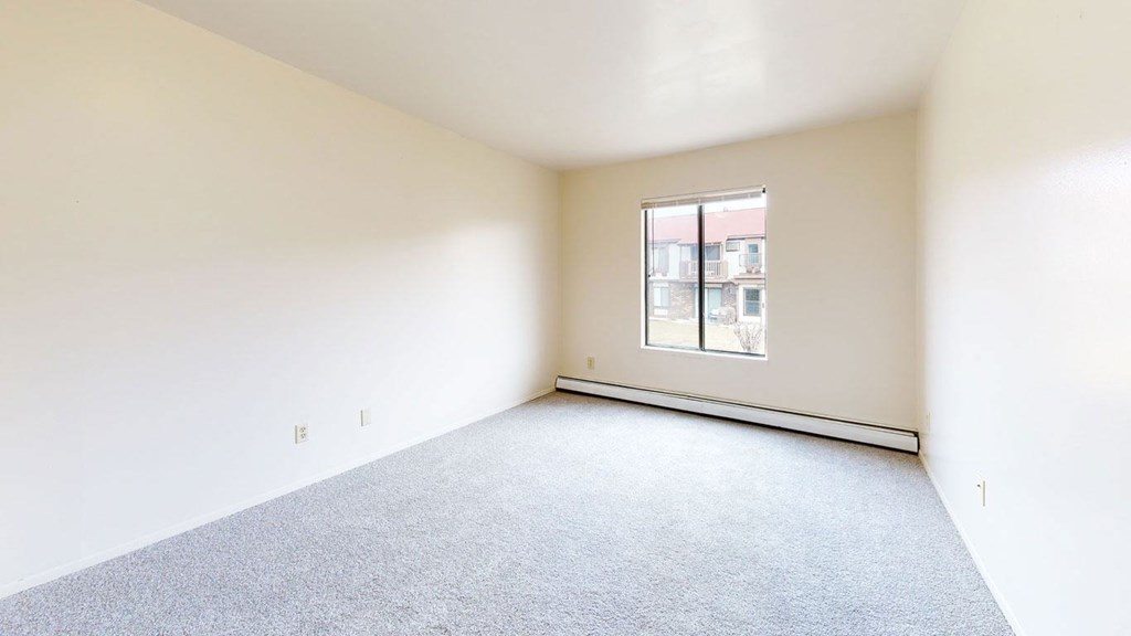 bedroom with carpet and a large window  at Wood Creek Apartments, Wisconsin