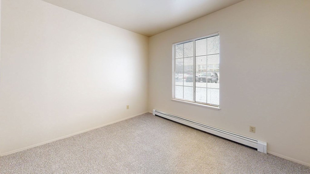 a bedroom with a large window and plush carpeting  at Wood Creek Apartments, Wisconsin, 53144