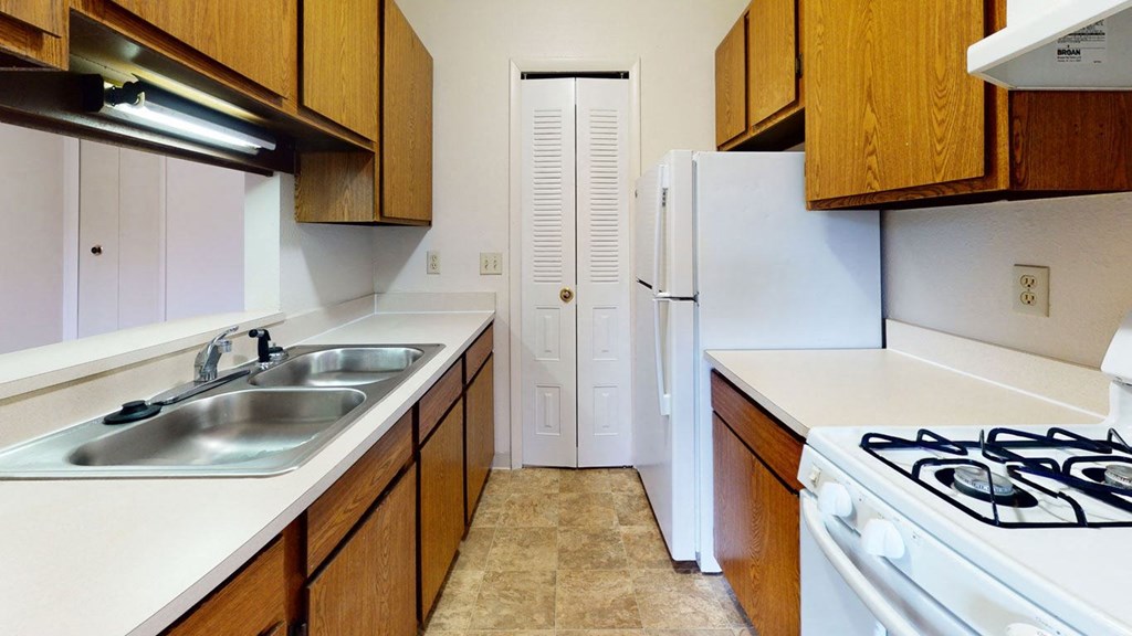 a kitchen with a door to a pantry  at Wood Creek Apartments, Wisconsin