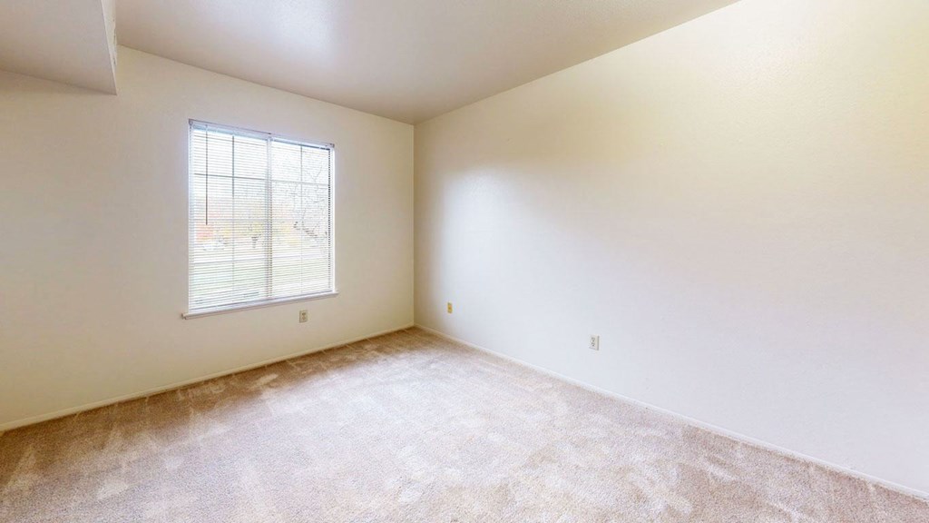a large bedroom with carpet and a window  at Wood Creek Apartments, Kenosha, WI, 53144