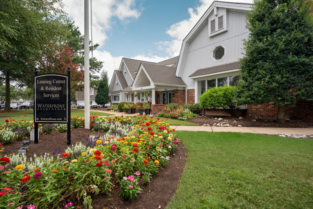 A sign for the Leasing Center & Resident Services at Waterfront is in front of a building.