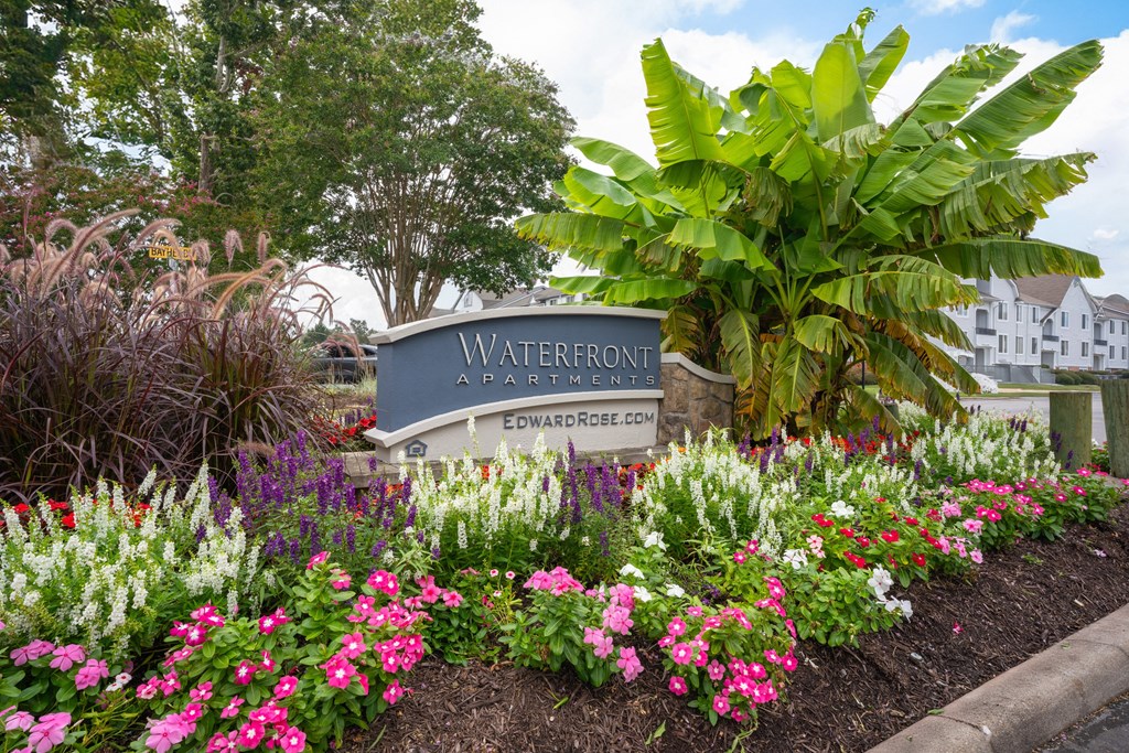 A sign that says Waterfront in front of some flowers.