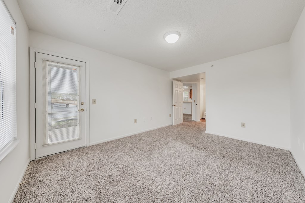 A room with a carpeted floor and a ceiling fan at WaterFront Apartments, Virginia Beach, 23453