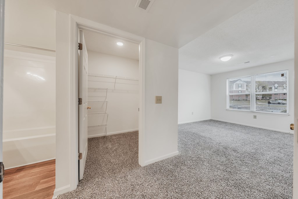 A room with a carpeted floor and a doorway leading to another room at WaterFront Apartments, Virginia Beach, 23453