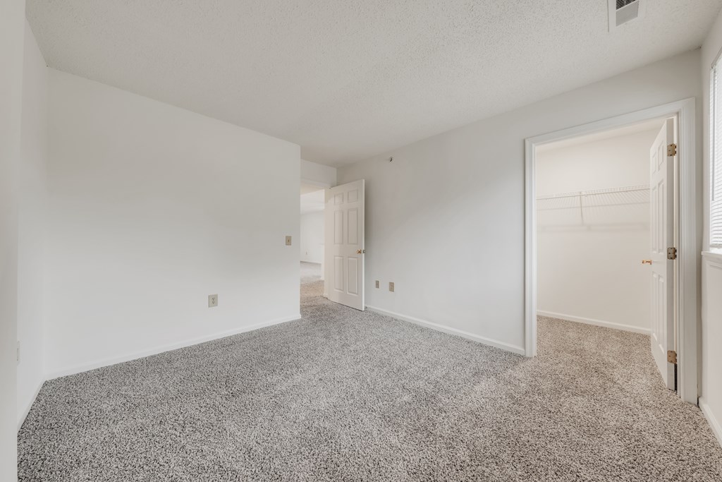 A sparsely furnished room with a carpeted floor and white walls at WaterFront Apartments, Virginia Beach, 23453