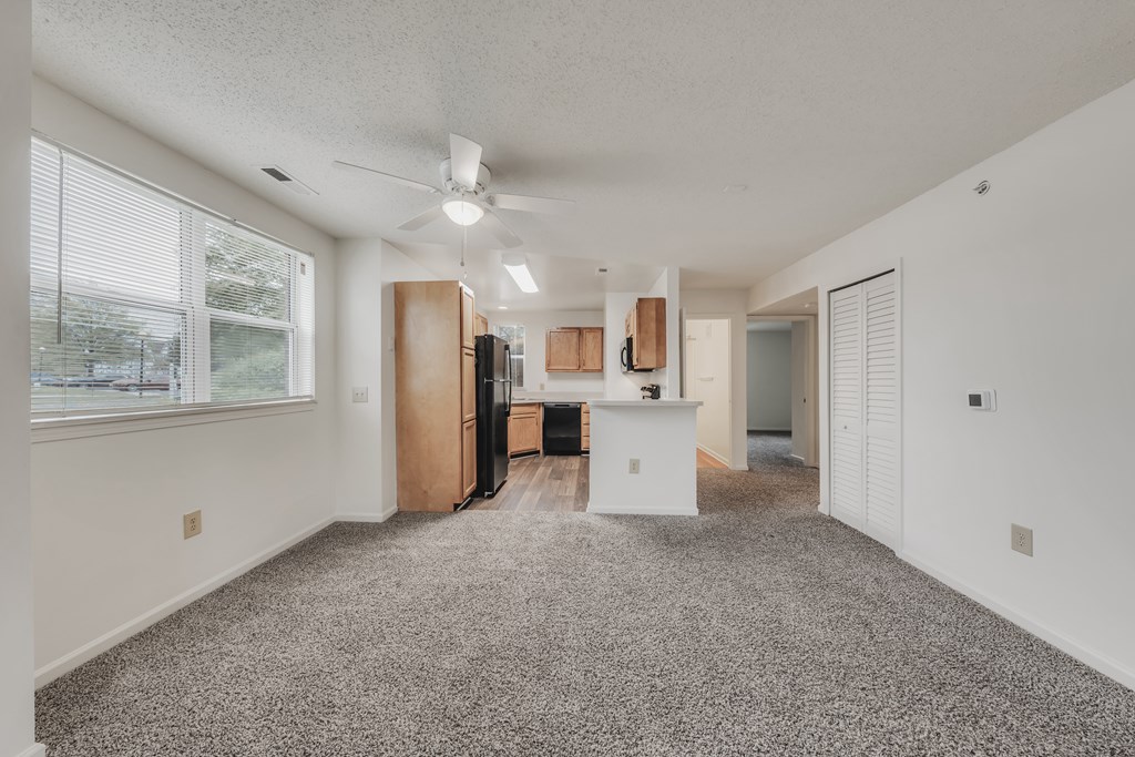 A spacious kitchen with a refrigerator, cabinets, and a ceiling fan at WaterFront Apartments, Virginia Beach, 23453