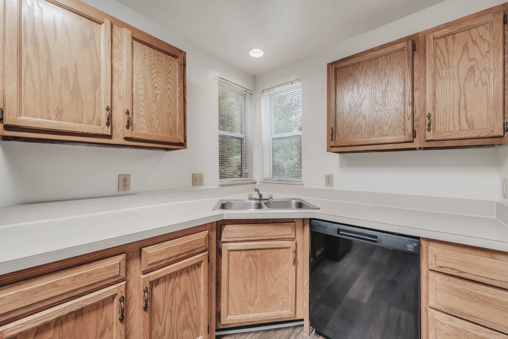 A kitchen with wooden cabinets and a dishwasher at WaterFront Apartments, Virginia Beach, 23453